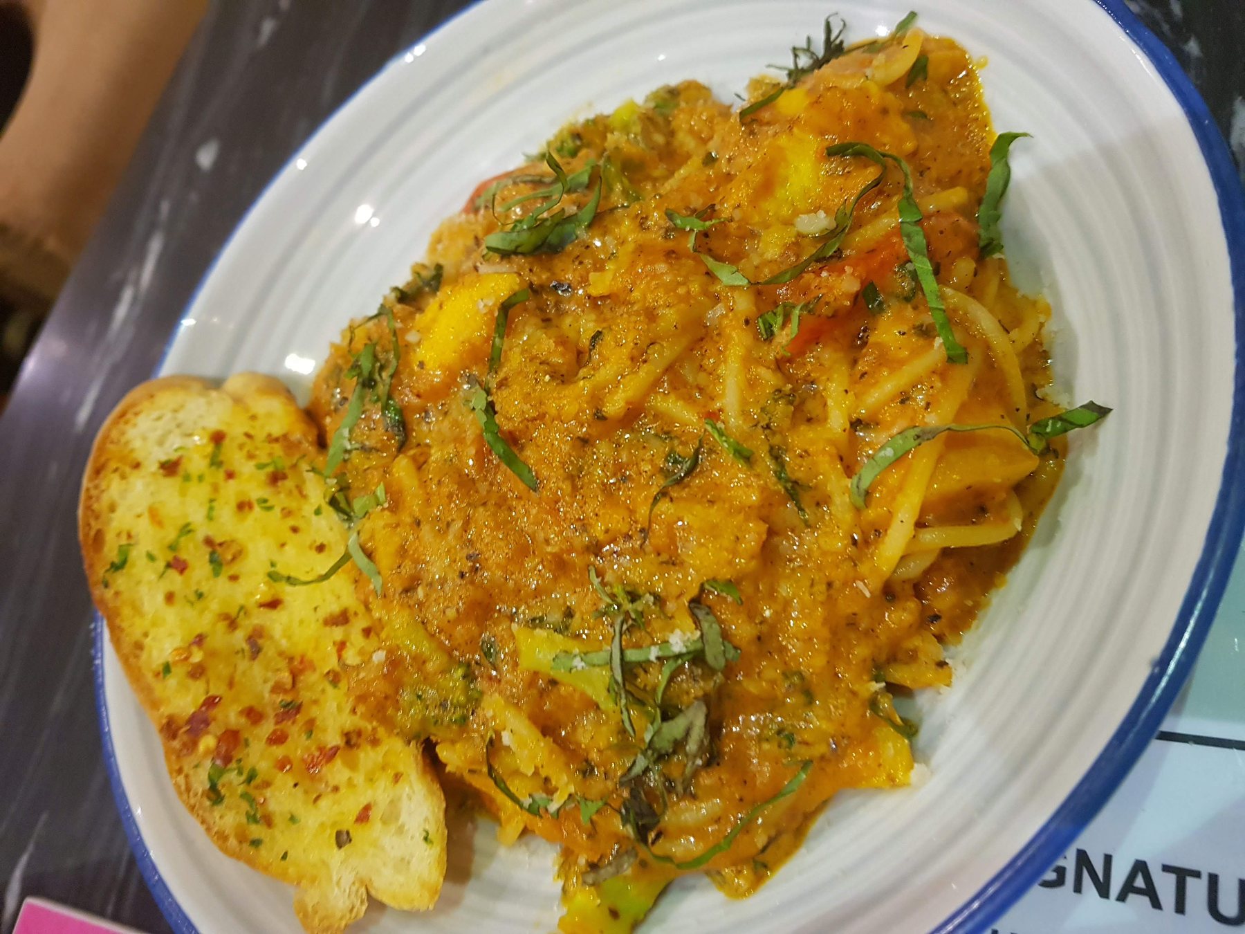 A carefully plated tomato pasta dish with herbs